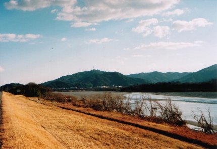 土手からの川と山と雲の写真